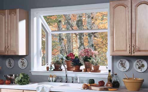 Garden window projecting from kitchen wall with plants on shelf