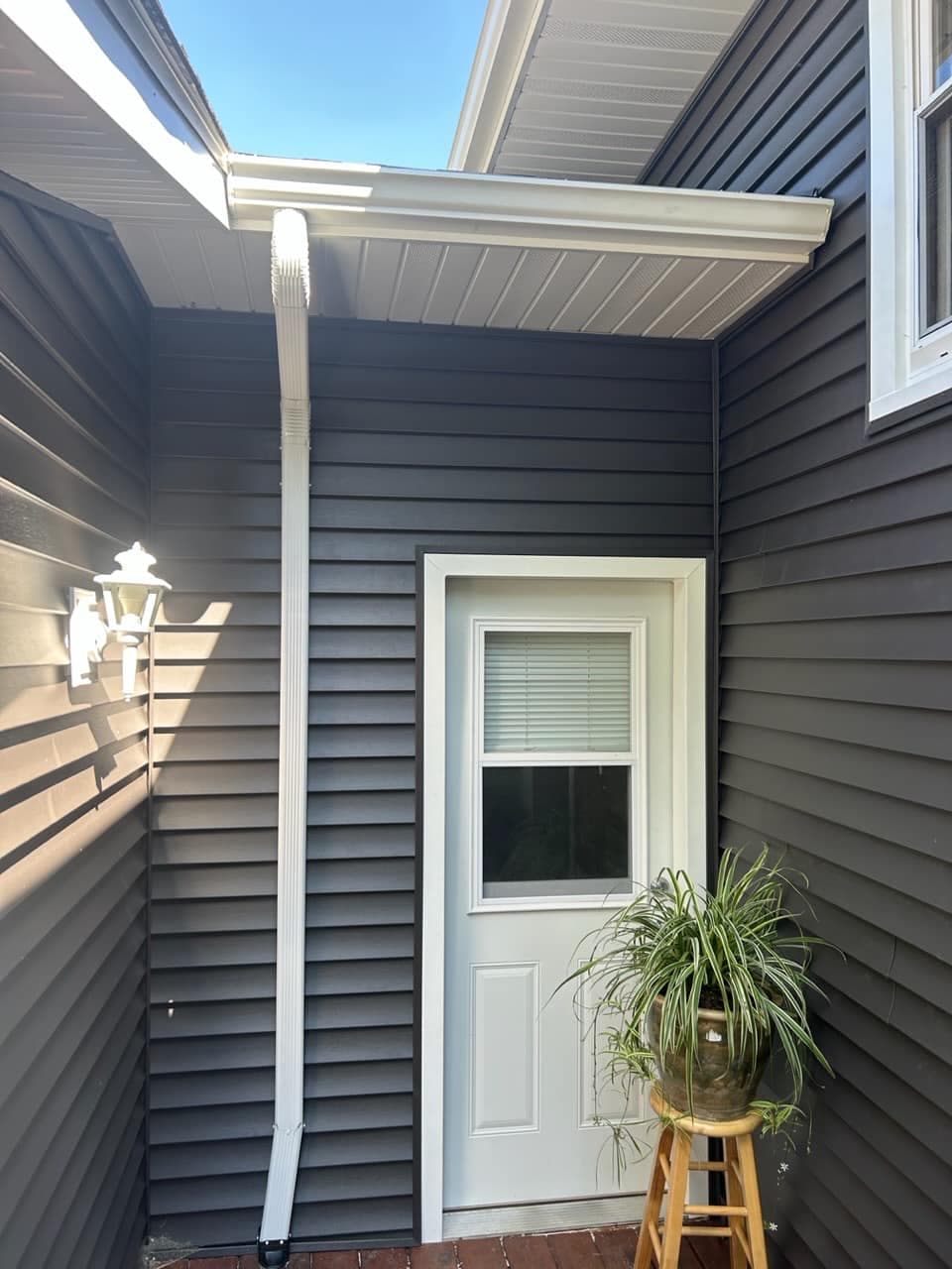 Gutter installation crew fabricating seamless gutters on site